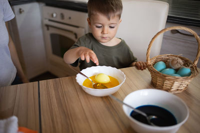 Portrait of cute baby boy eating food on table