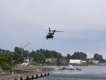 Airplane flying over water against sky