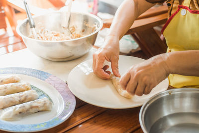Midsection of woman preparing food at table
