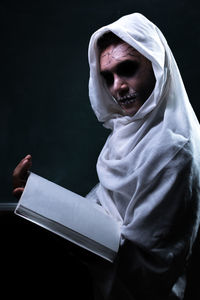 Portrait of mature man sitting against black background