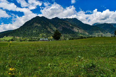 Scenic view of field and mountains against sky