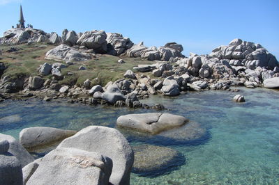 Rocks on beach against clear sky