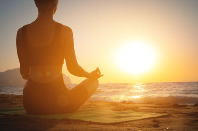 Meditation and yoga on the beach. concept of doing yoga on summer vacation or vacation by the sea