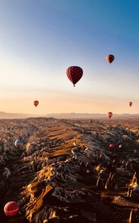 Hot air balloons flying over landscape