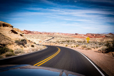 Road leading towards mountain against sky