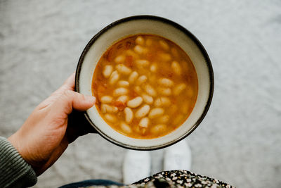 Cropped hand of woman holding coffee on table