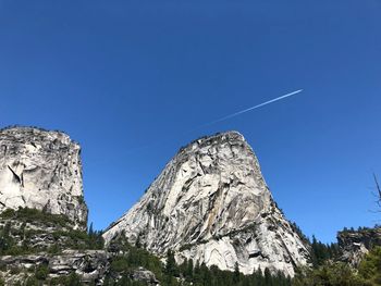 Low angle view of rock formation against clear blue sky