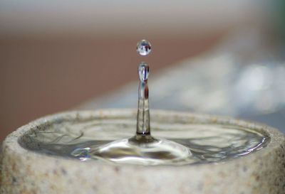 Close-up of drop falling on water