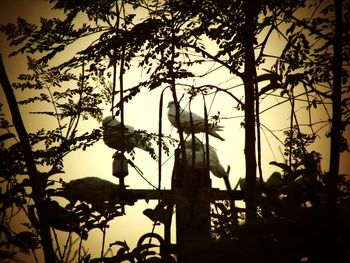 Low angle view of silhouette trees against sky