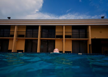 Portrait of woman in swimming pool against sky