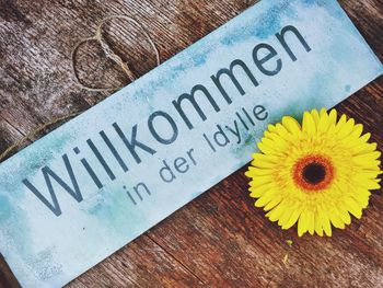 Welcome sign with yellow daisy on table