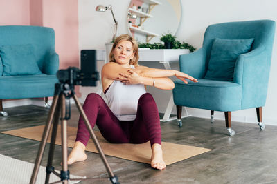 Young woman sitting on sofa at home