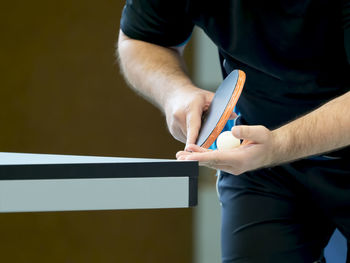 Midsection of man playing table tennis