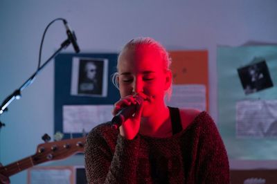 Singer singing in illuminated studio