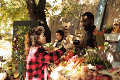 Side view of woman holding food at park