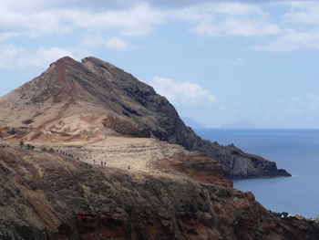 Scenic view of rocky mountains and sea against sky