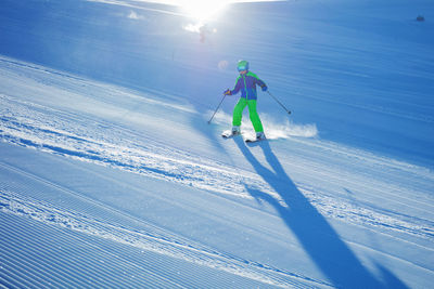 Rear view of man skiing on snow covered landscape