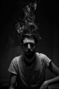 Smoke emitting from man head against black background