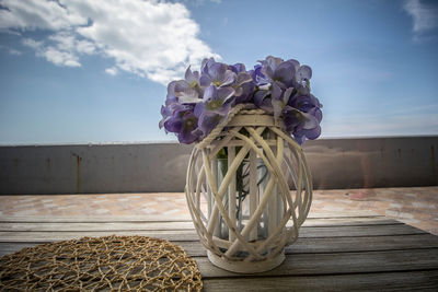 Close-up of vase on table against sky