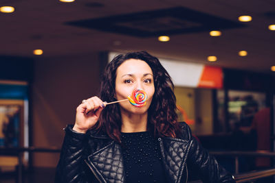 Portrait of young woman with lollipop