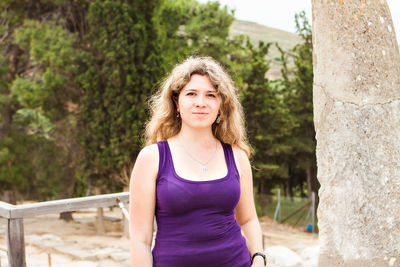 Portrait of smiling woman standing against plants