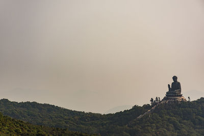 Large buddha statue on mountain against sky