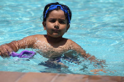 Portrait of shirtless boy swimming in pool