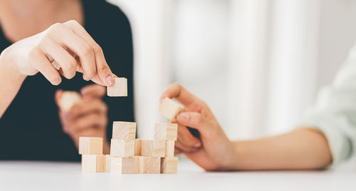 Midsection of woman with toy on table