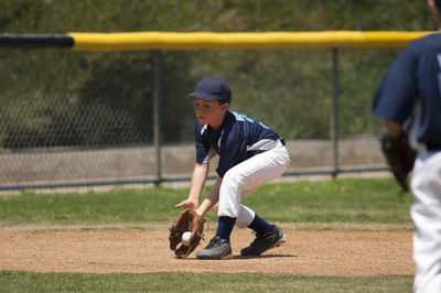 Little league baseball infielder fielding a ground ball