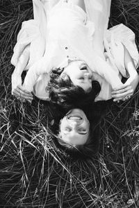 Portrait of smiling young woman and girl lying on grass
