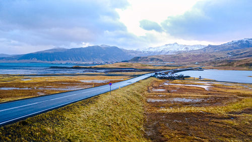 Scenic view of lake by mountains against sky