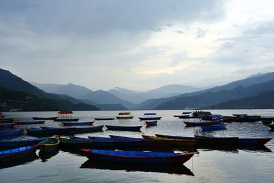 Boats moored in lake against sky