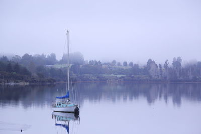 Boat sailing on river against sky