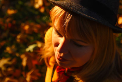 Closeup portrait of candid young caucasian blonde woman in colorful autumn park. bright dark stylish