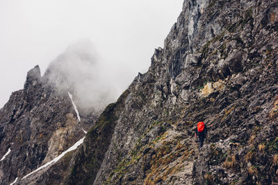 Rear view of hiker on rocky mountain