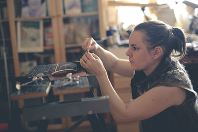 Craftsman woman works with decoration, makes the base of copper metal under the enamel, the concept 