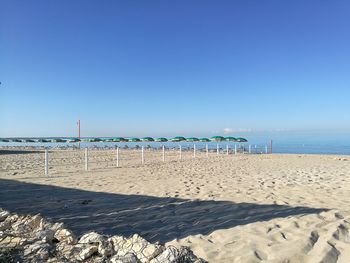 Scenic view of beach against clear blue sky