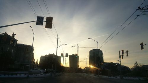 Cars on road against sky during sunset