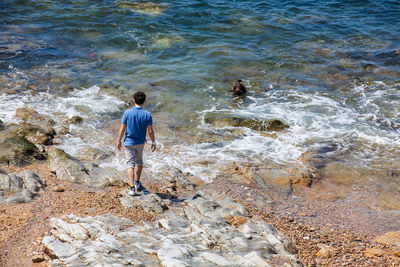 High angle view of men on rock at beach