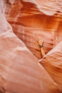 Hand with fitness watch against slot canyon wall in escalante, utah.