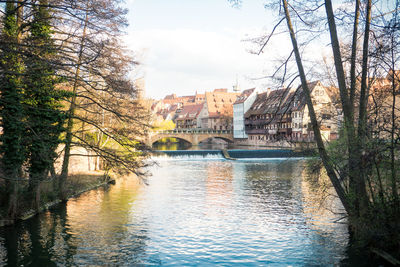 Arch bridge over river against buildings