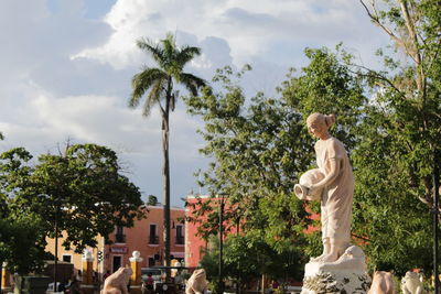 Statue amidst trees against sky