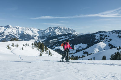 Man skiing on snowcapped mountain against sky