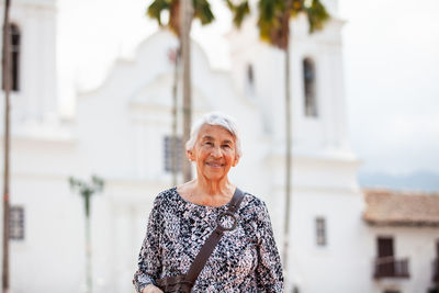 Senior adult woman at the central square in the city of guaduas. senior travel concept.