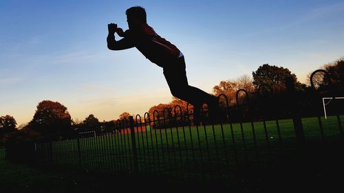 Man on field against sky during sunset