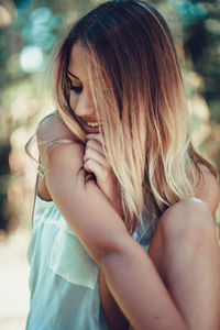 Midsection of woman with hair sitting outdoors