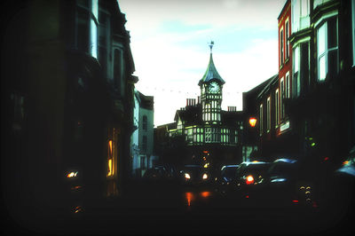 Cars on street amidst buildings in city against sky