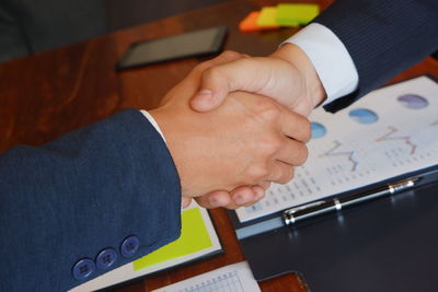 Cropped image of business people shaking hands in office 