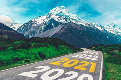 Road sign by mountain against sky