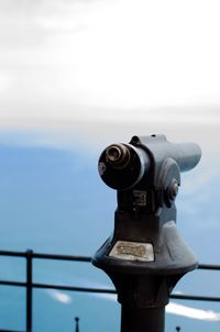 Close-up of coin-operated binoculars against sky